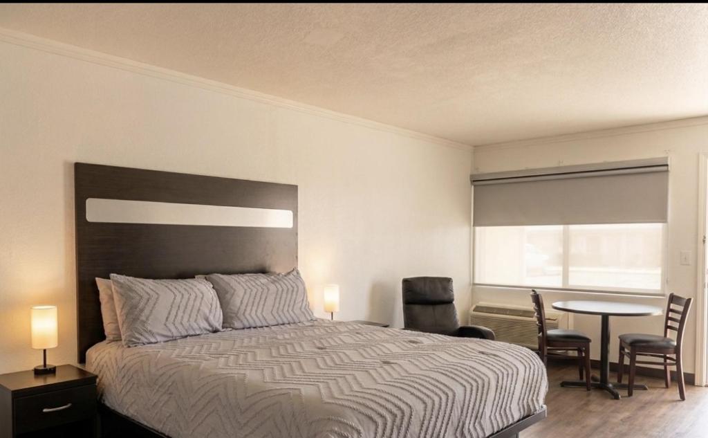 a bedroom with a bed and a table and chairs at Big Chief Motel in Battle Mountain