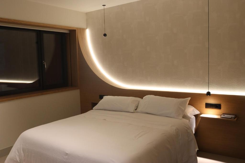 a bedroom with a white bed and a window at Acouga in Miñortos