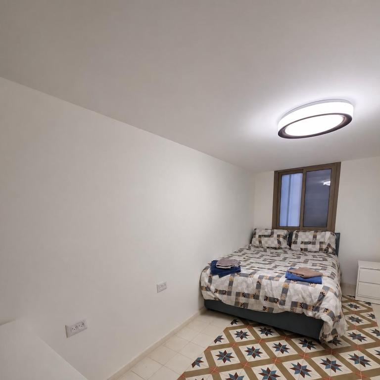 a bedroom with a bed and a window at Ja guest house in Tel Aviv