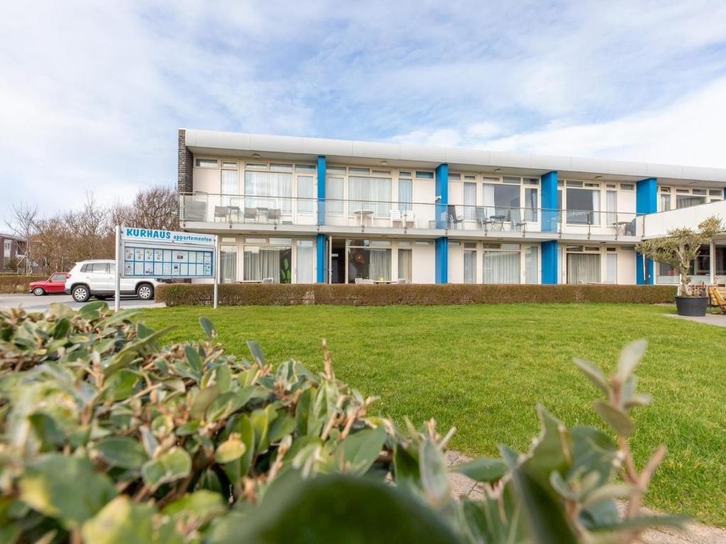a building with a green field in front of it at Coastal Escape w Sauna in Zoutelande