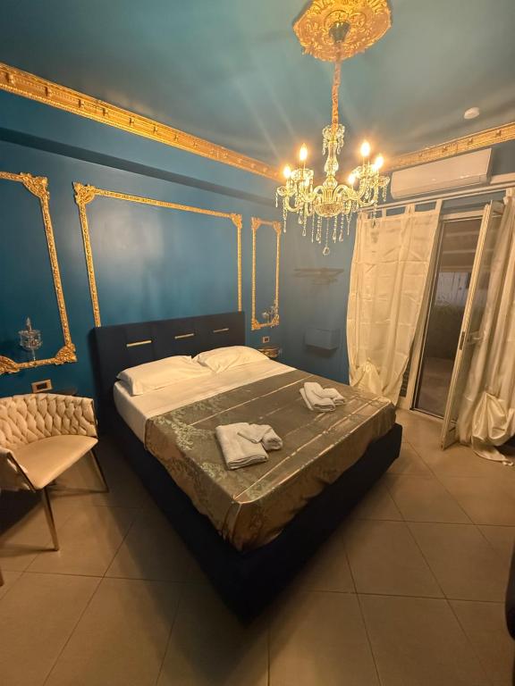 a bedroom with a bed and a chandelier at XVI Secolo House in Scalea