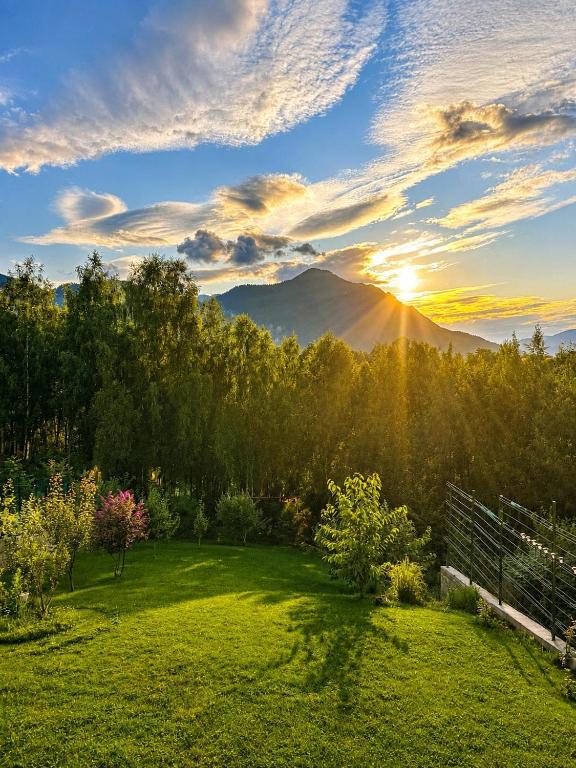 a view of a field with the sun setting over a mountain at Crai Stone House in Bran