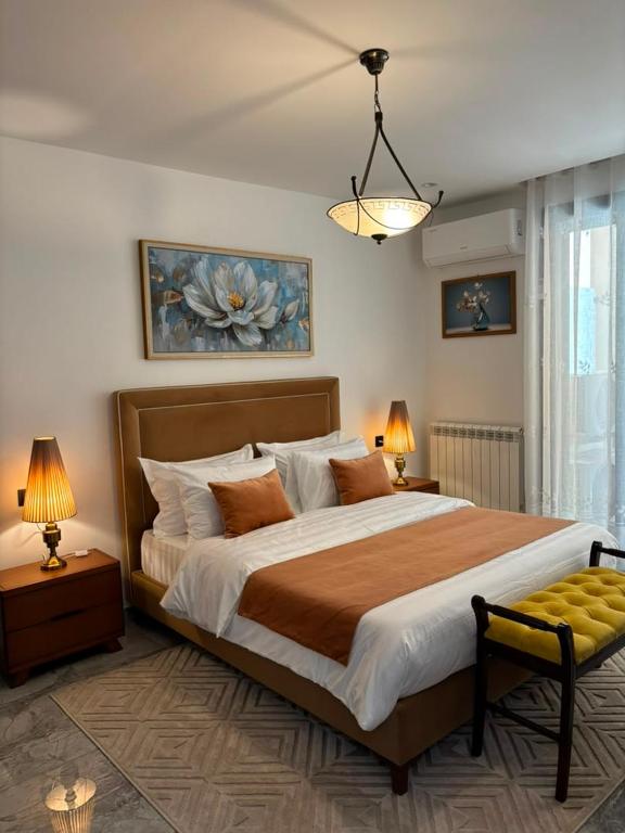 a bedroom with a large bed and two lamps at Bel appartement in Cheraga