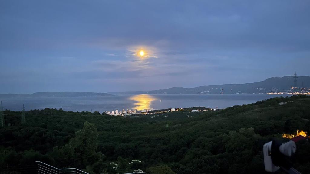 a view of the moon over the water at night at Terra Magica Deluxe Sea View Apartment or Room with Free Parking in Rijeka