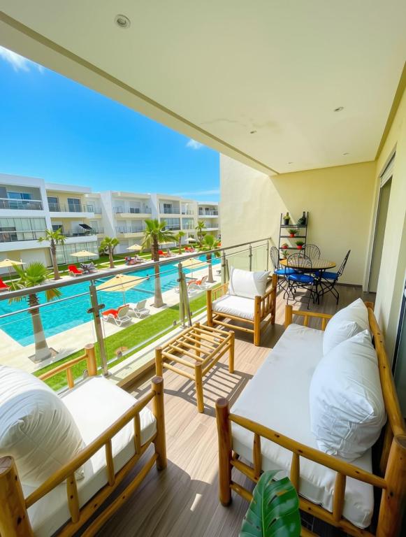 a balcony with beds and a view of a pool at 2BR Pool View Kids Pool & Gym 6 Min to Beach in Dar Hamida