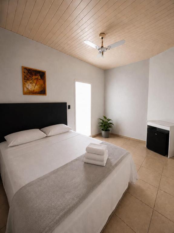 a bedroom with a bed with two towels on it at Cantinho Da Go in Caraguatatuba