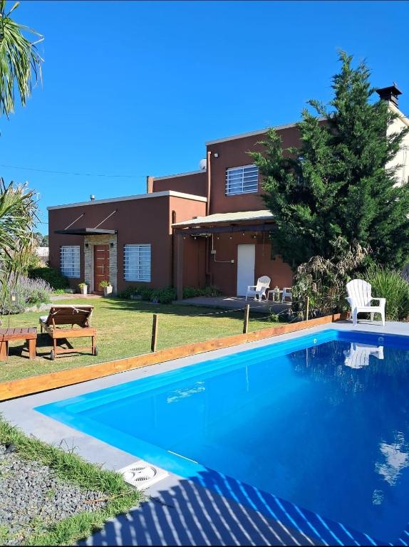 a house with a swimming pool in front of a house at El Bagual de Monte XL in San Miguel del Monte