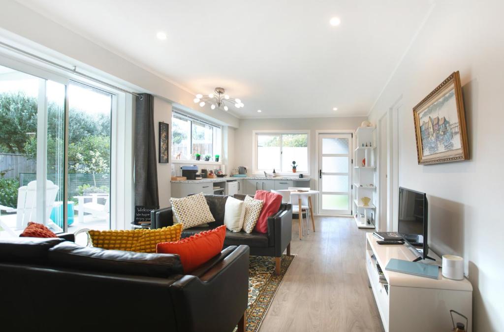 a living room with two couches and a television at Waikanae Beach Suite Retreat in Waikanae