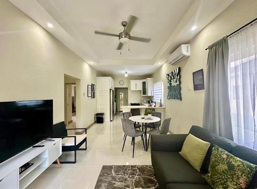 a living room with a couch and a tv and a table at Villa cool breeze in Steer Town