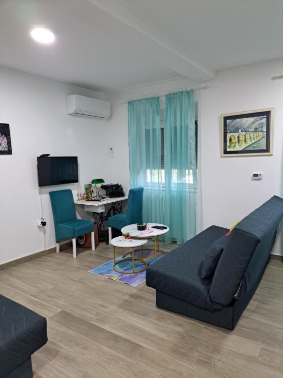 a living room with a couch and chairs and a table at Apartman Jass in Stari Banovci