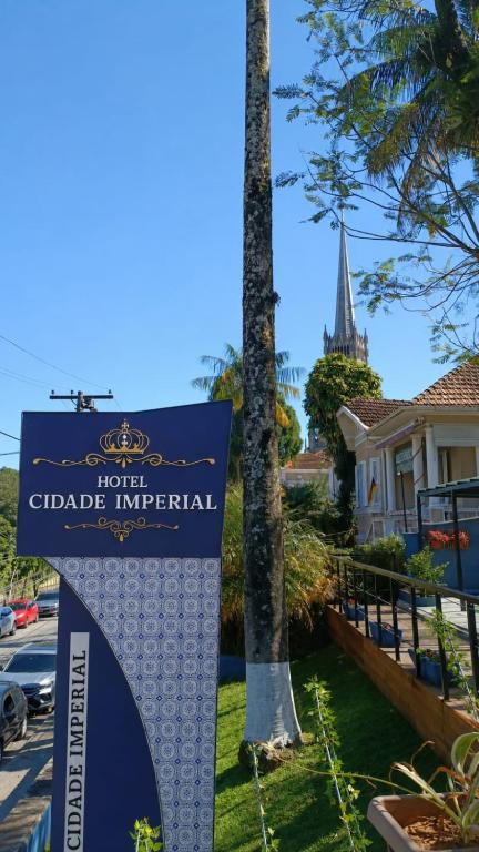 a sign in front of a house with a church at Hotel Cidade Imperial in Petrópolis
