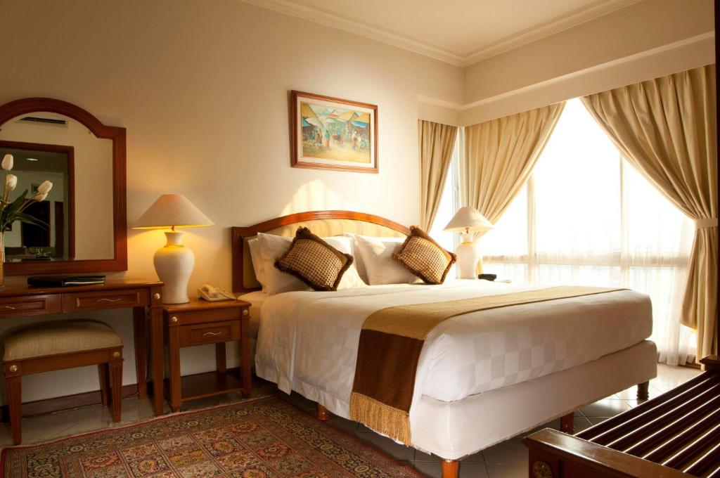 ジャカルタにあるThe Residences at Puri Casablancaのベッドルーム(ベッド1台、デスク、鏡付)