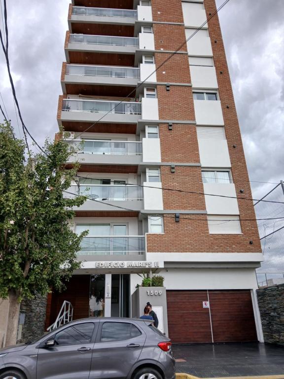 a car parked in front of a tall building at Punto Sur Apart in Río Cuarto