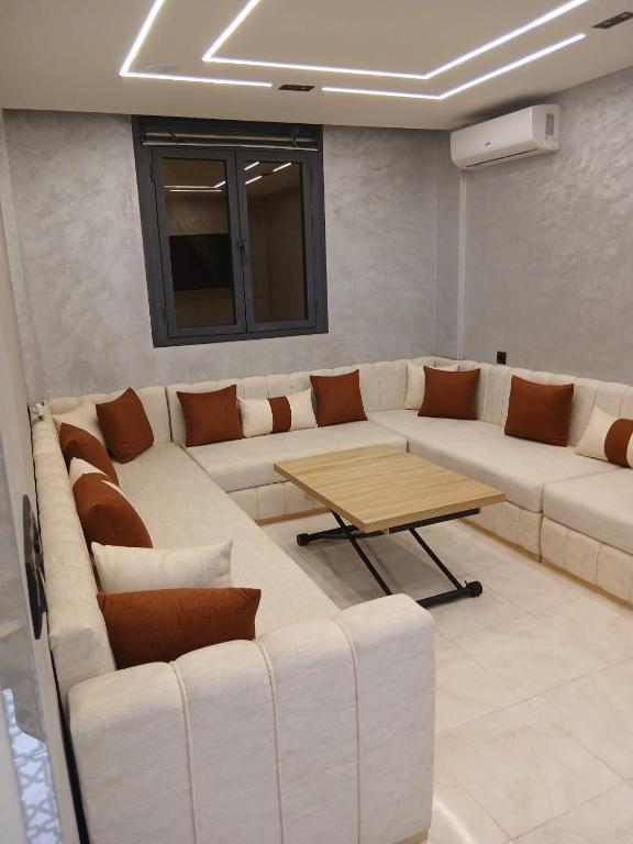 a living room with a white couch and a table at Ikamat raha in Tangier