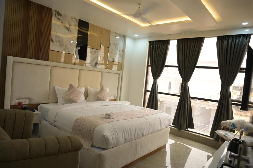 a bedroom with a large bed and a large window at Hotel Surya Inn in Patna
