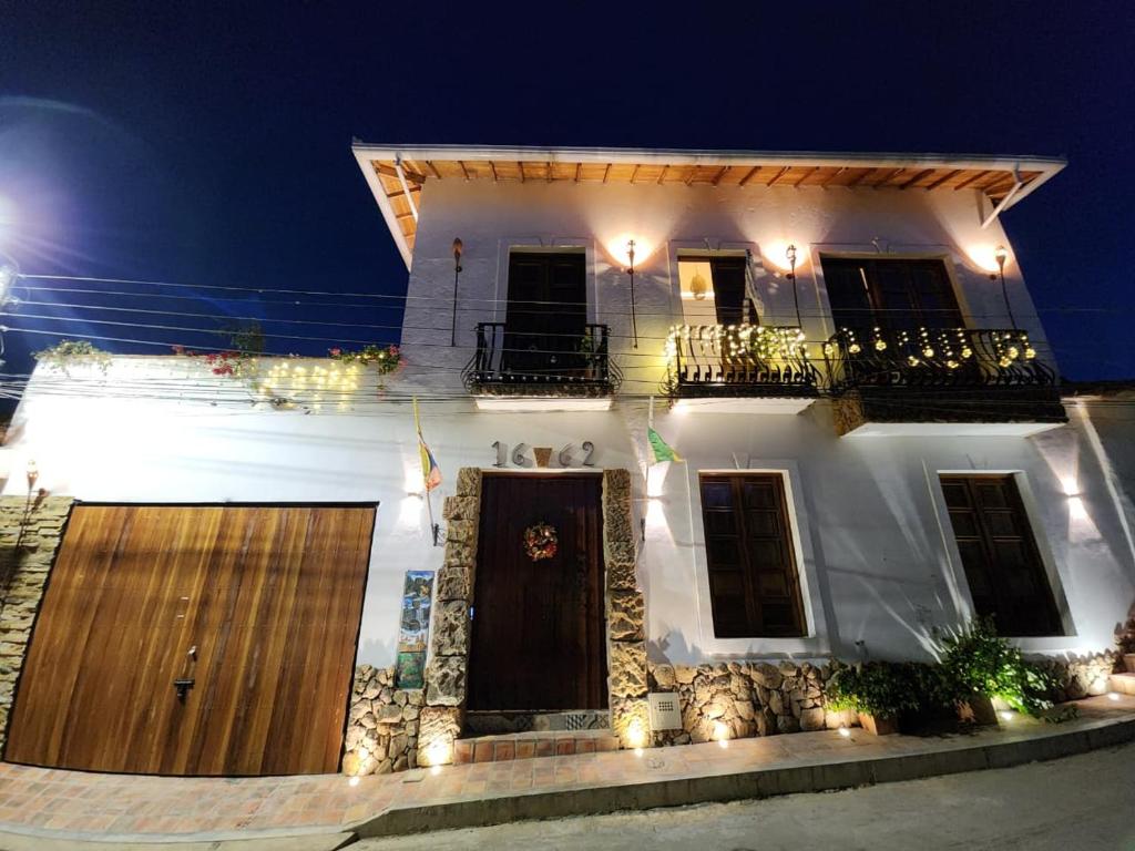 a white house with a gate and a balcony at Casa Carmesí Zapatoca in Zapatoca