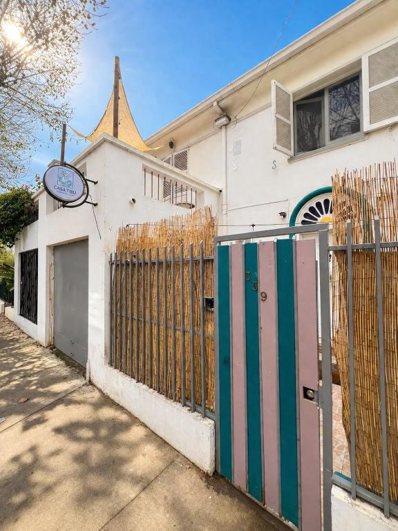 a white building with a gate and a fence at Casa Tribu in Viña del Mar