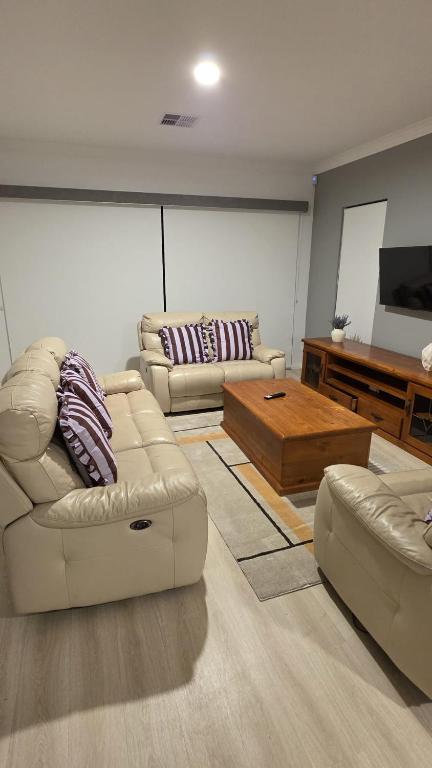 a living room with two couches and a television at Seahawk Escape in Mandurah