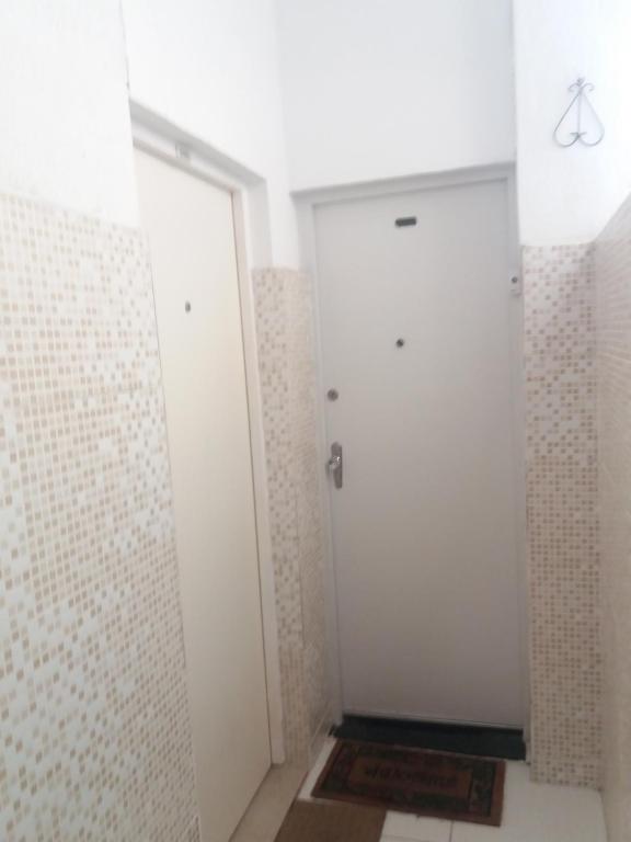 a bathroom with two white doors and a tile wall at Praia II de Copacabana in Rio de Janeiro
