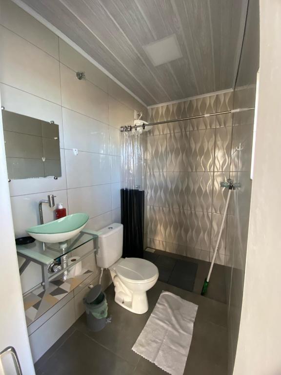 a bathroom with a toilet and a sink at Loft Da Rosa in Rio Grande