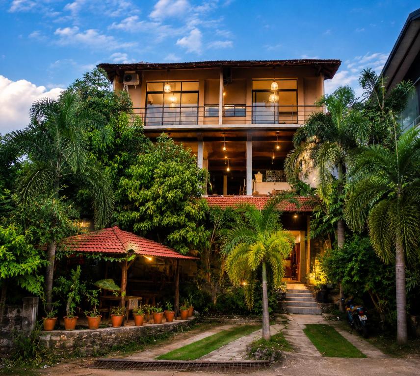 a house with palm trees in front of it at Ella Brown House in Ella