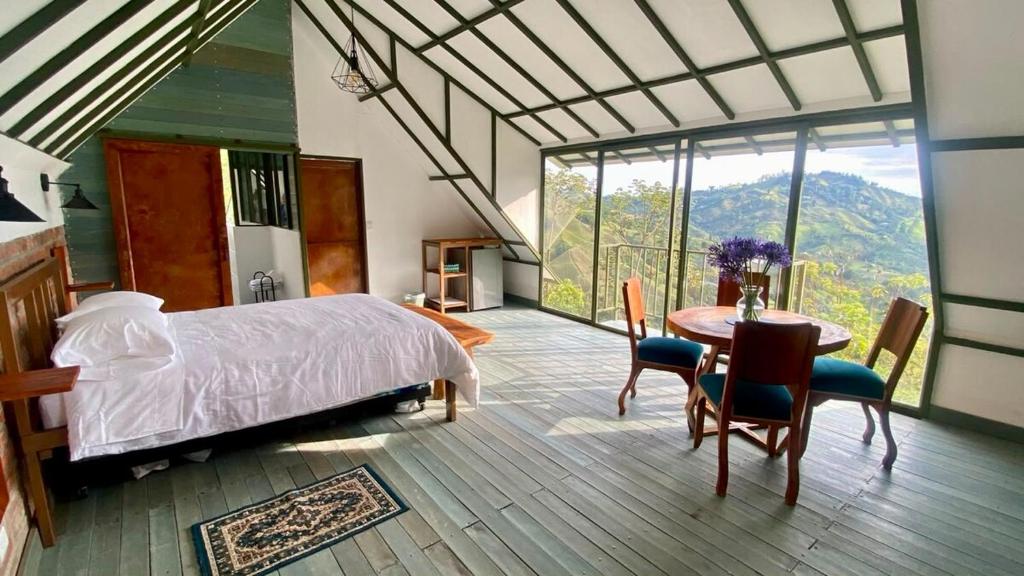 a bedroom with a bed and a table and chairs at La Photinia in Villamaría