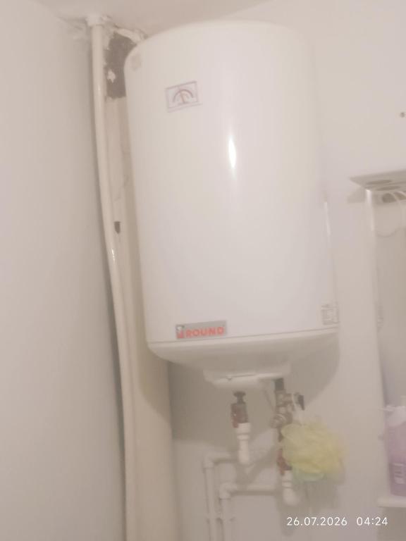 a refrigerator with a water tank in a room at Gazda ialoveni in Ialoveni