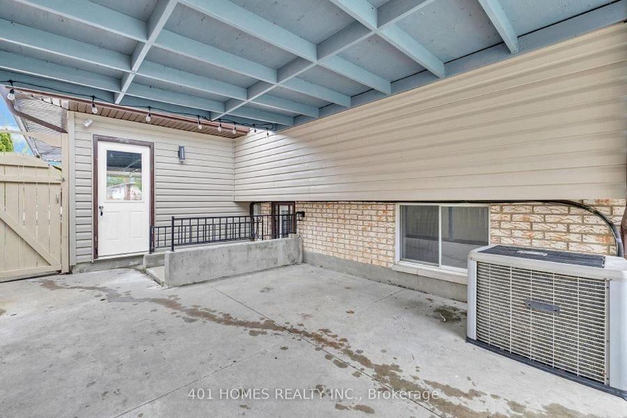 a house with a patio with a fan next to a building at Cozy Private Basement Suite East Windsor in Windsor