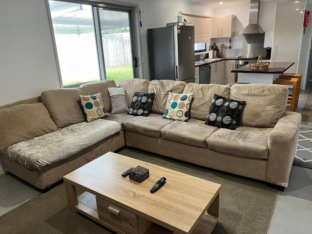 a living room with a couch and a coffee table at 2 bedroom private unit with enclosed back yard in Bairnsdale