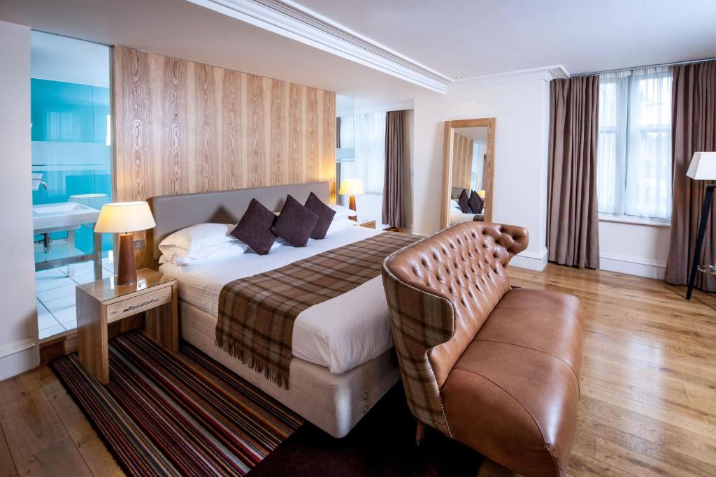 a hotel room with a bed and a chair at ABode Canterbury in Canterbury