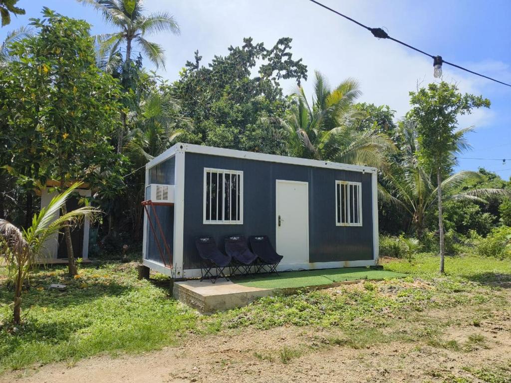 a tiny house with two chairs in a yard at Calicoan Surf Retreat unique family room in Guiuan