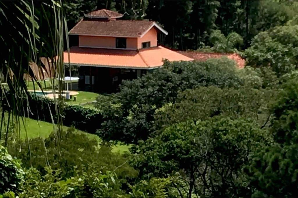 a house in the middle of a forest of trees at Rancho Batatas in Atibaia