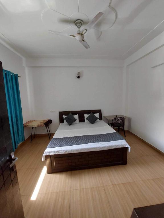 a bedroom with a bed and a ceiling fan at Hotel O Naveen Residancy in Manesar