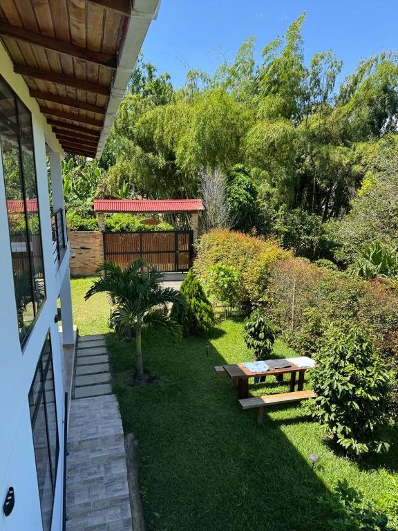a garden with a picnic table and a bench at Meraki Cabaña Privada in Pereira