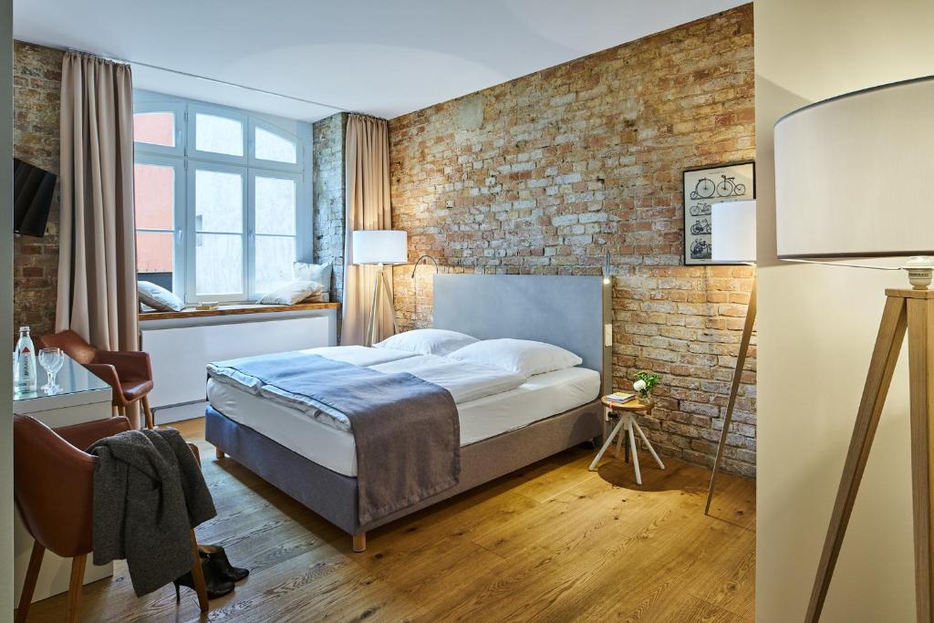 um quarto com uma cama e uma parede de tijolos em Hotel 38 em Berlim