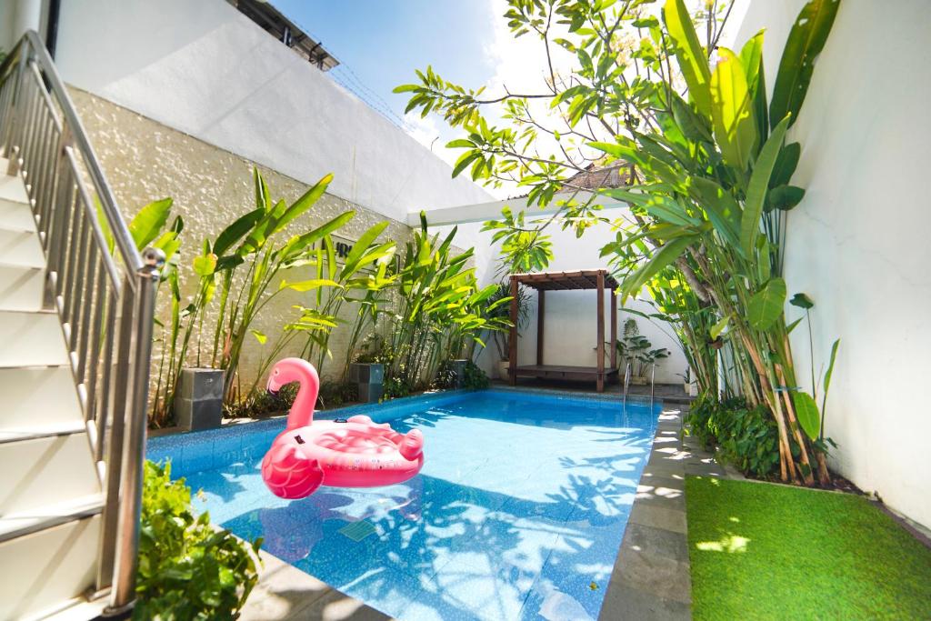 a swimming pool with a pink swan in a house at Spacious Family-friendly Villa with Swimming Pool in Gondowulung
