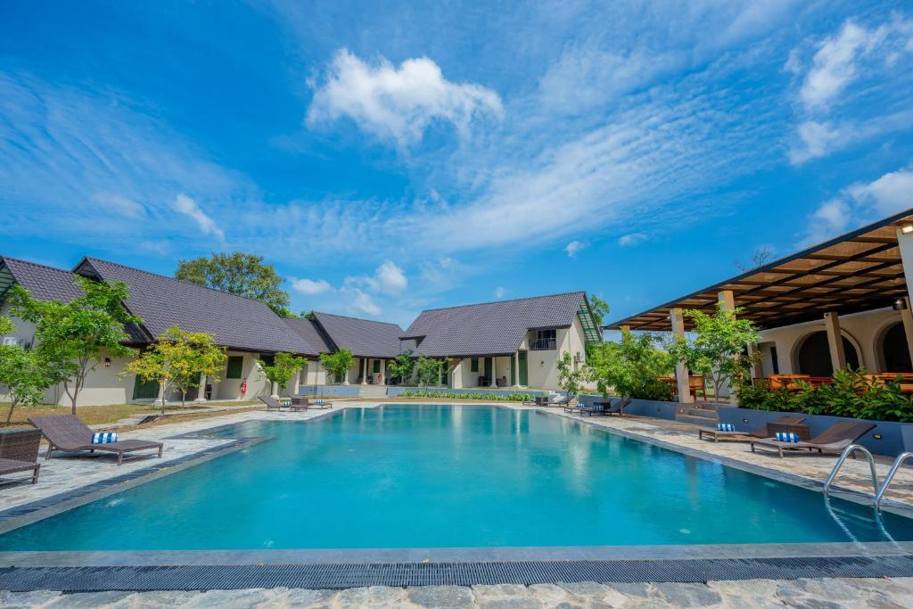a swimming pool in a house with blue water at Cape Sigiriya in Sigiriya