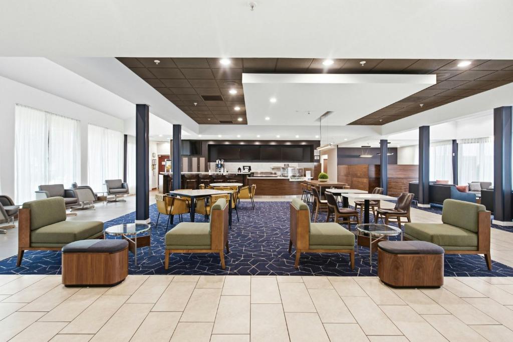 eine Lobby mit Tischen und Stühlen sowie eine Cafeteria in der Unterkunft Courtyard by Marriott Columbus in Columbus