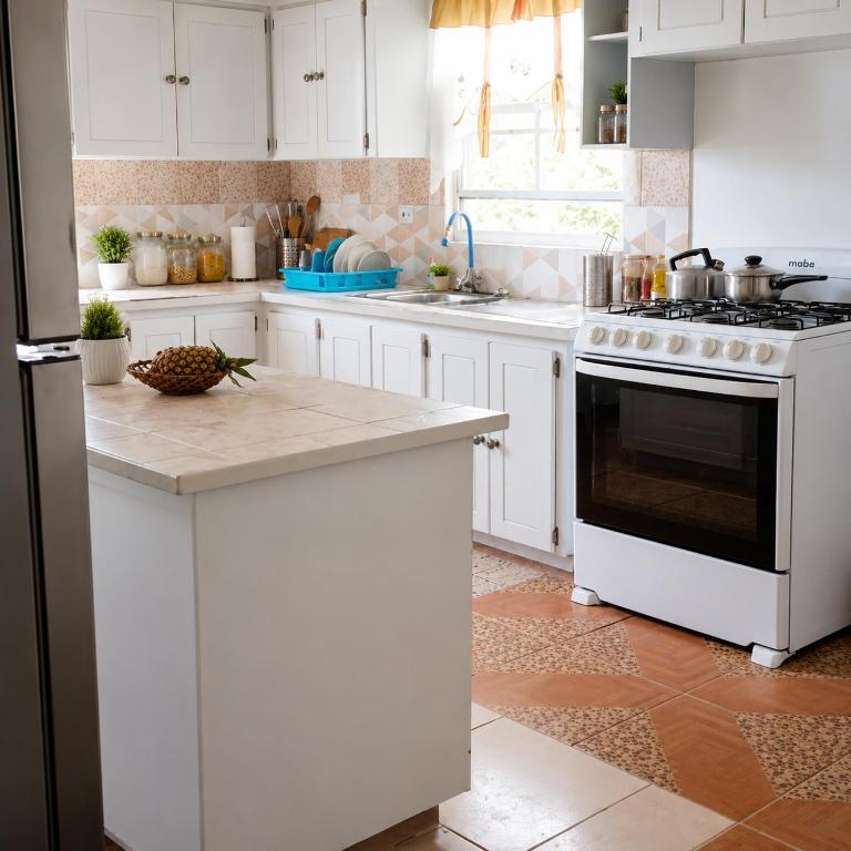 a kitchen with white cabinets and a black and white stove at Liz B&B Hideaway in Saint Georgeʼs
