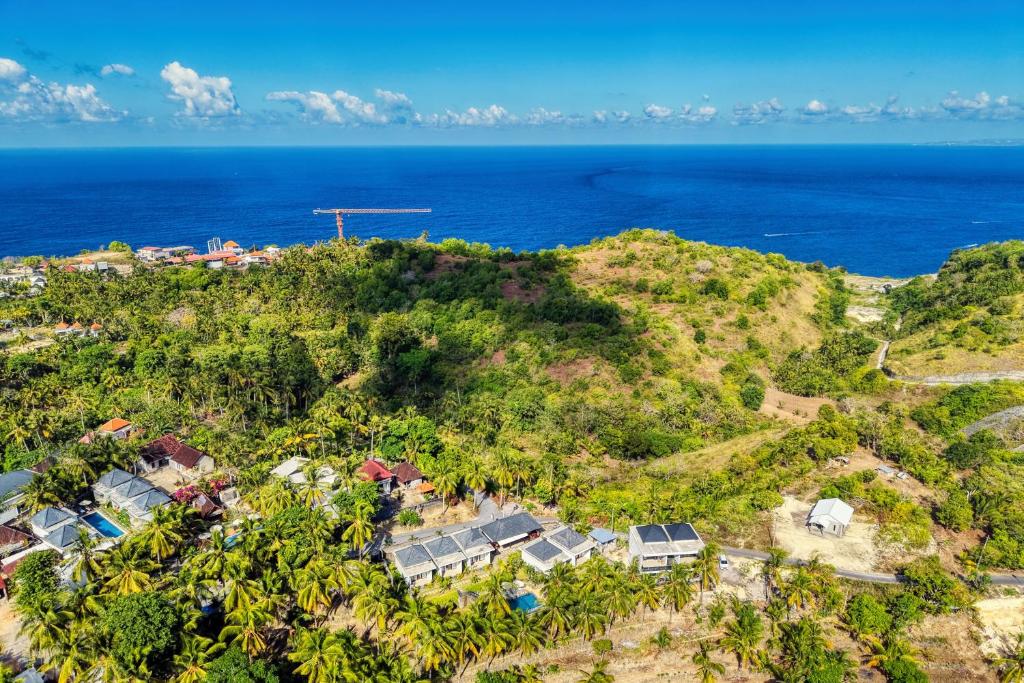an aerial view of a house on a hill with the ocean at Kelingking Puri Suci Villa in Nusa Penida