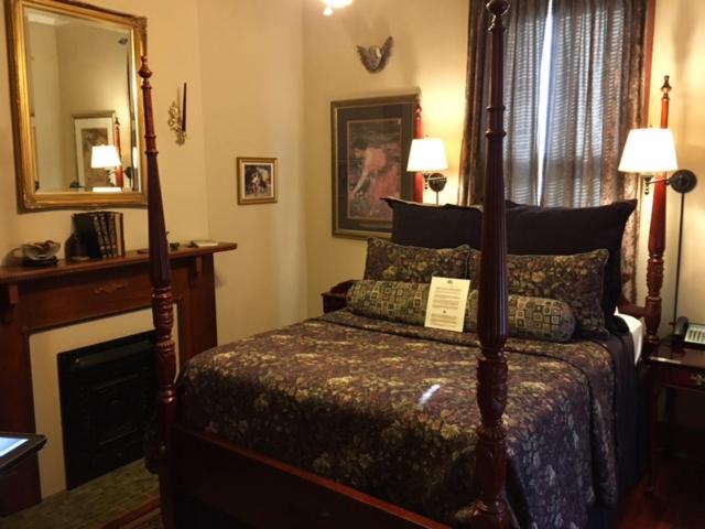 a bedroom with a canopy bed and a mirror at 1896 O'Malley House in New Orleans