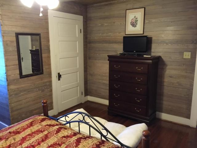 a bedroom with a bed and a dresser with a television at 1896 O'Malley House in New Orleans