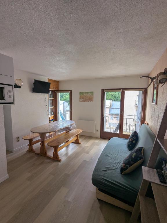 a living room with a table and a couch at Appartement au centre de Barèges in Barèges