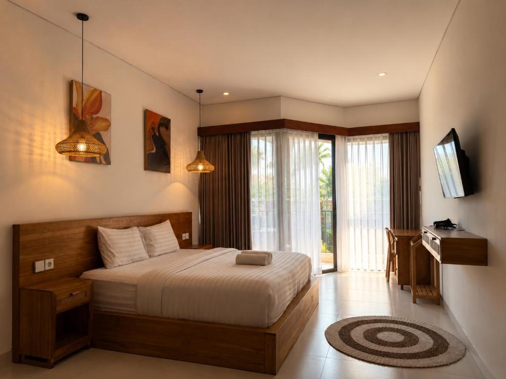 a bedroom with a bed and a television in it at Braban Sari Guest House Seminyak in Seminyak