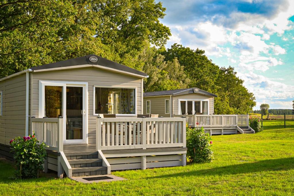 a tiny house in a yard with a porch at Ferienwohnung-Wiesenwinkel in Kasel-Golzig