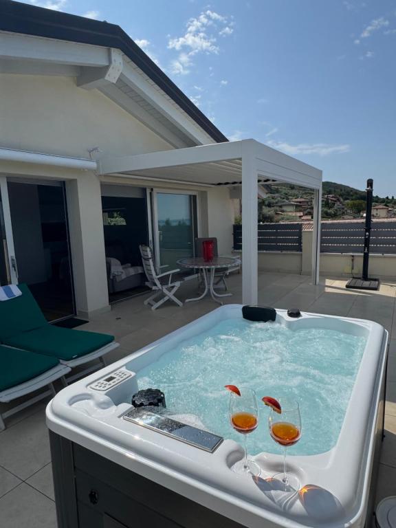 two wine glasses in a hot tub on a patio at Villa Cà bianca in Torri del Benaco