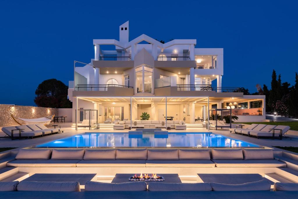 a large white house with a swimming pool at night at Monte Smith Luxury Villas in Rhodes Town