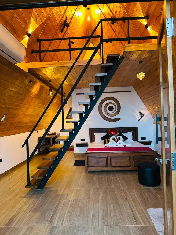 a bedroom with a large bed and a staircase at Eagle View villa in Ella