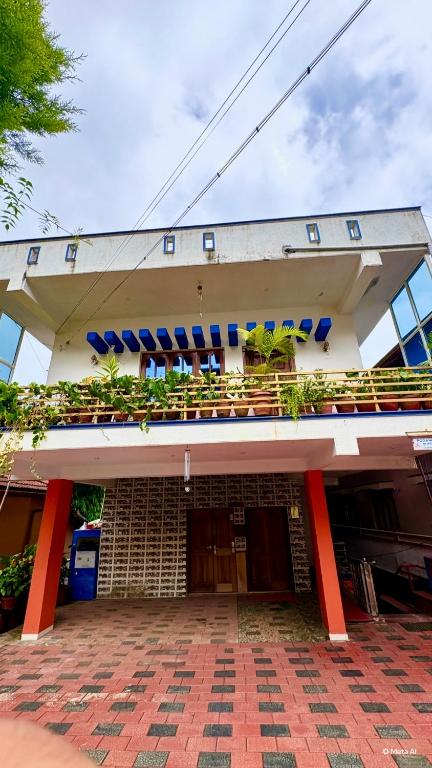 a building with a balcony with plants on it at Podanolana residency- Sleep Above the Clouds in Madikeri