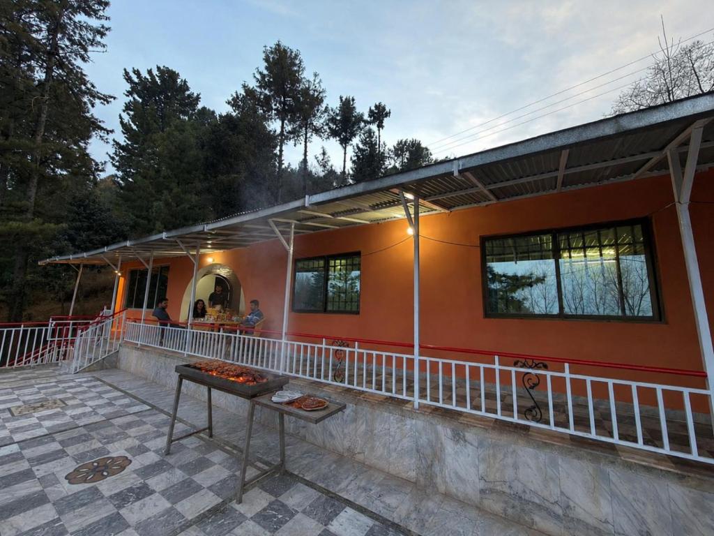 a house with a grill in front of it at Canopy Court Farmhouse Murree in Bhurban
